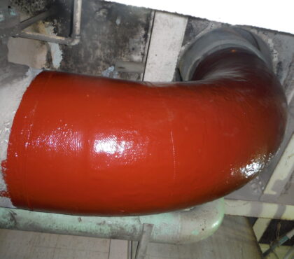 A long-radius elbow is repaired with carbon fiber composite and topcoated with epoxy