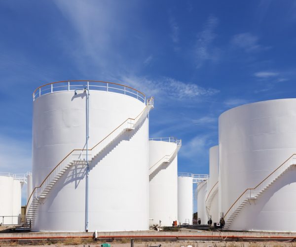 White fuel storage tank against blue sky