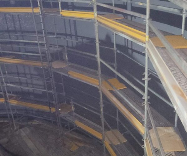 Scaffolding against the wall inside a spray dry absorber to paint industrial coating.