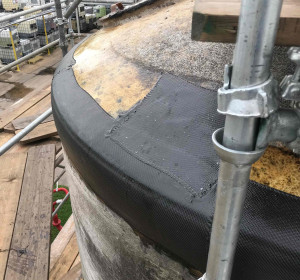 View of repaired tank roof with black composite repair patch.