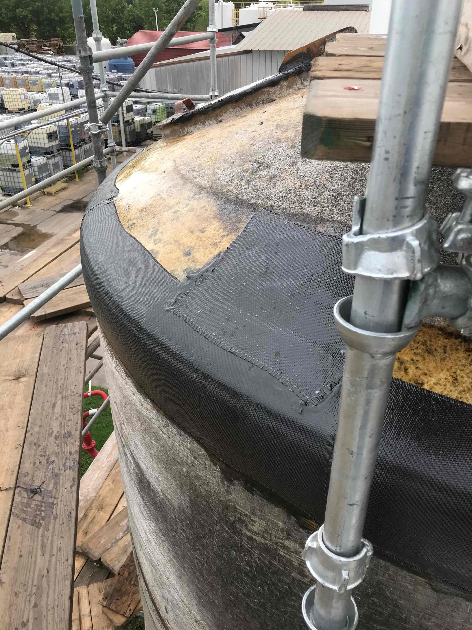 View of repaired tank roof with black composite repair patch.