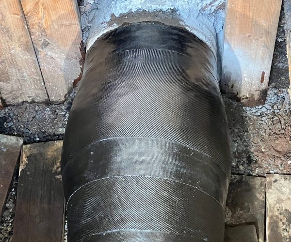 Bird's eye view of a large pipe with black composite wrap around the pipeline.