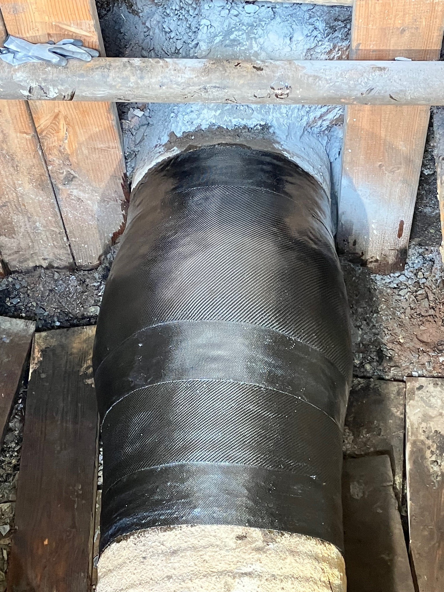 Bird's eye view of a large pipe with black composite wrap around the pipeline.