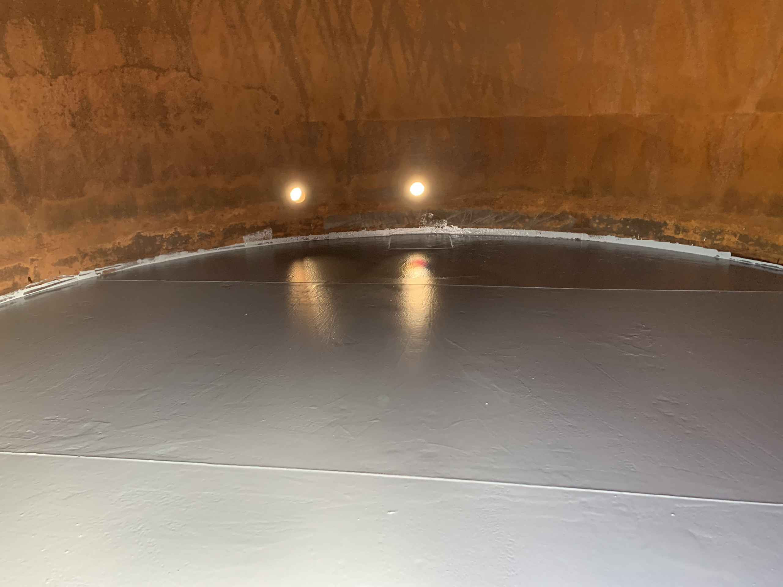 View of the inside of tank with epoxy coating on the floor of the tank.
