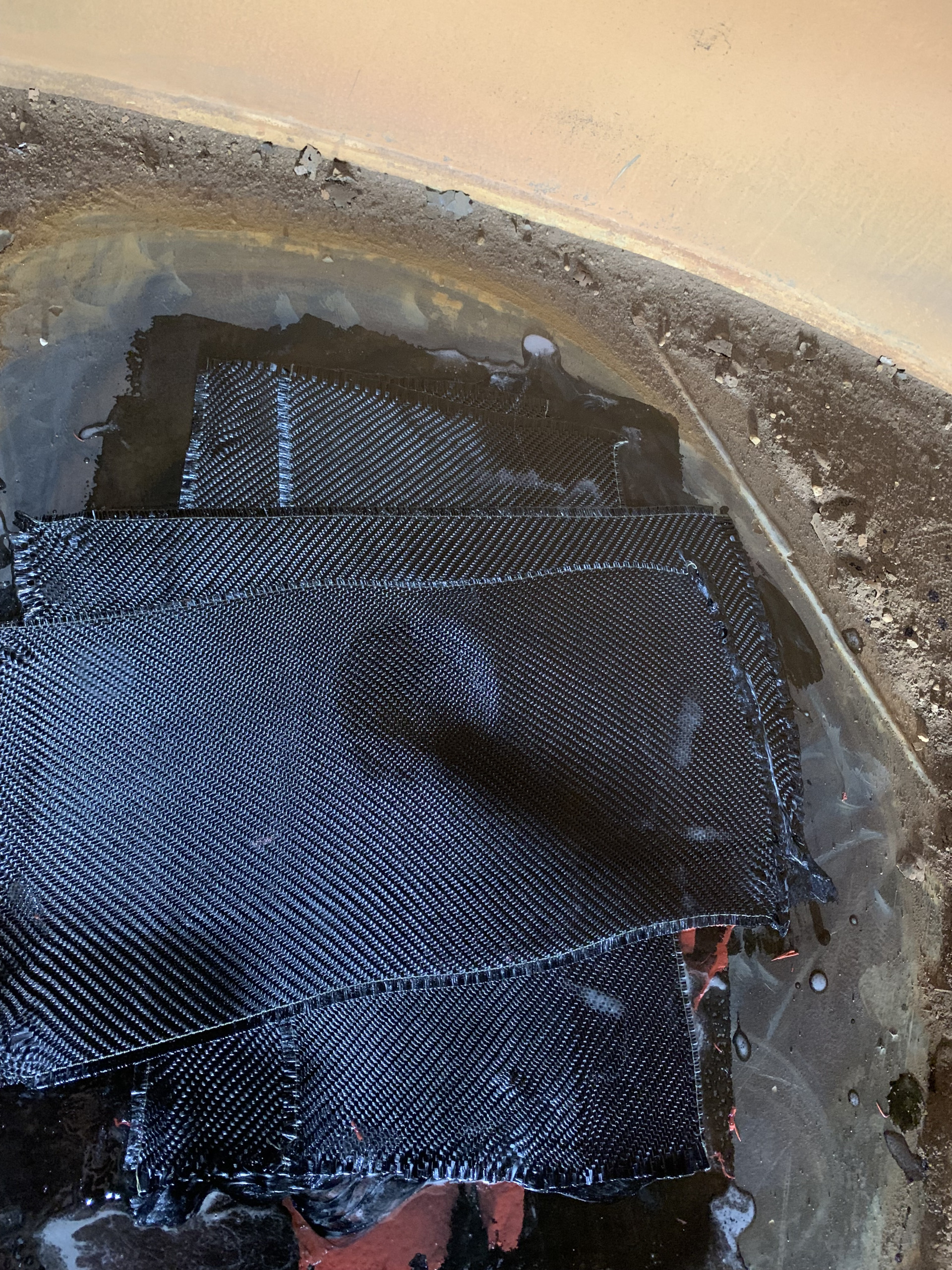 Composite fabric repairing a hole in a tank