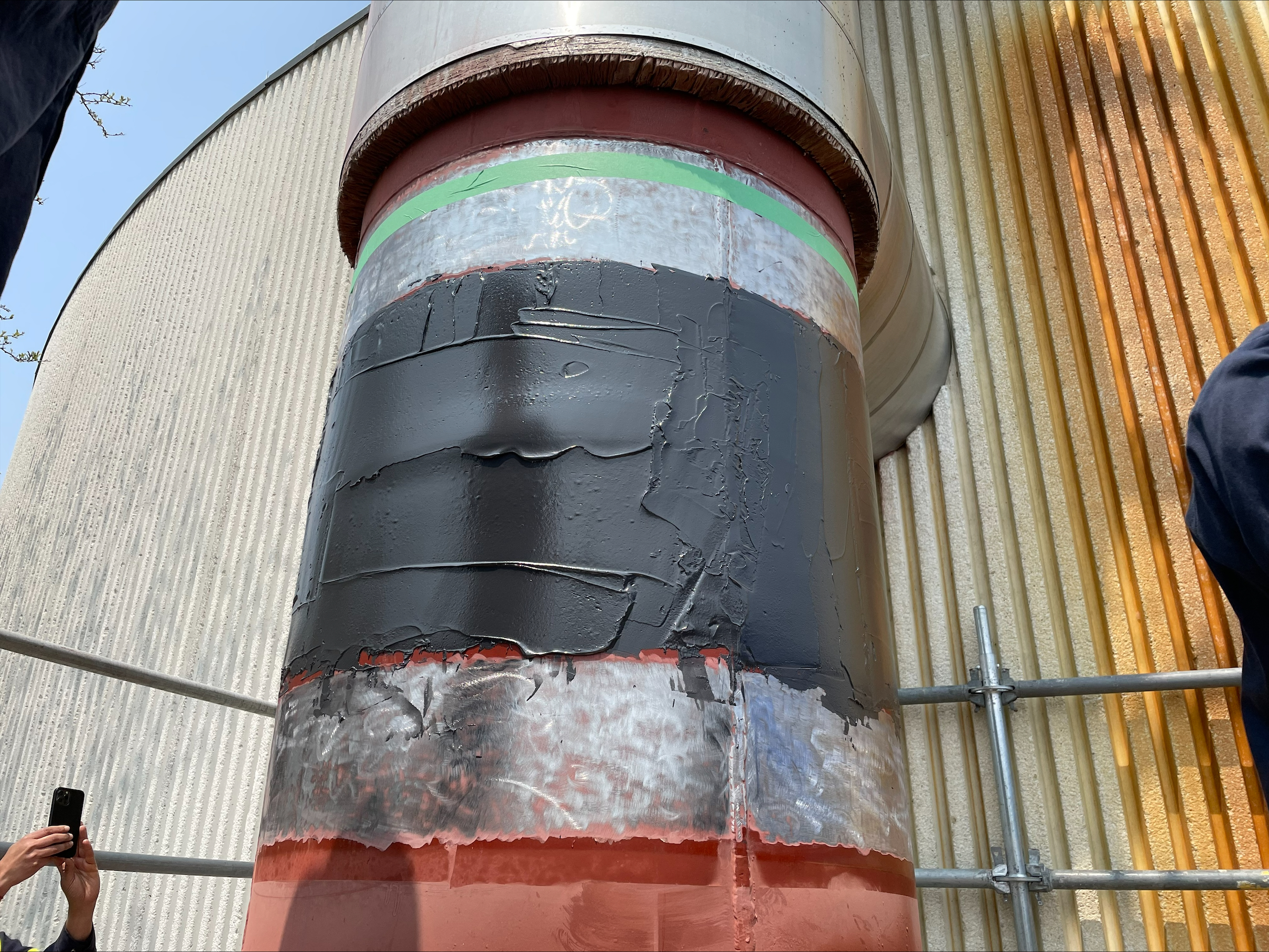 Large diameter vertical pipe outside facility wrapped around the width with carbon fiber composite repair material.