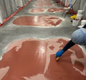 Applicator applying repair putty to the floor.