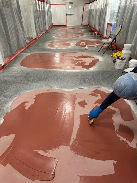 Applicator applying repair putty to the floor.