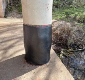 Column repair showing black fabric composite wrapped around the base