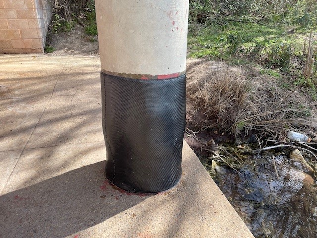 Column repair showing black fabric composite wrapped around the base